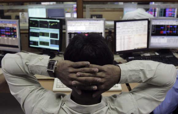 A broker monitors share prices at a brokerage firm in Mumbai.