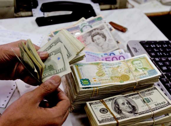  A cashier counts currency notes at one of Syria's commercial banks in Damascus.