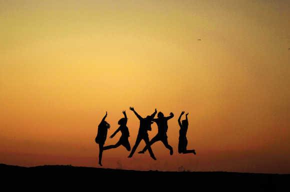 People jump off a sand bank in Venice, Los Angeles, California.