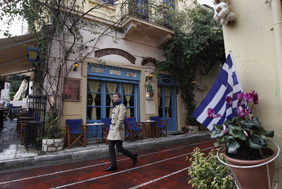 A man walks in front of a cafe at Plaka tourist district in Athens.