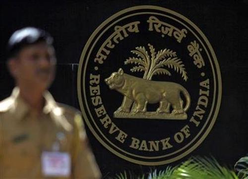 A policeman walks past the logo of the Reserve Bank of India (RBI) outside its head office in Mumbai