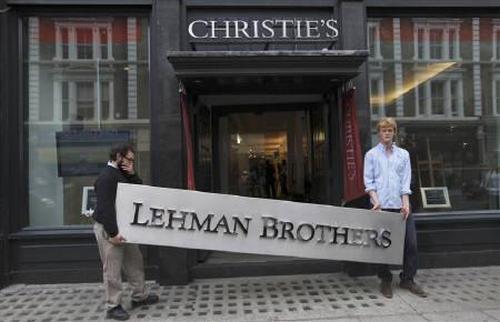 Christie's employees pose for a photograph with a Lehman Brothers sign at Christie's in central London