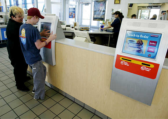 Customers use a computer terminal called a kiosk to order breakfast at a McDonalds restaurant in the Denver suburb of Littleton, Colorado.