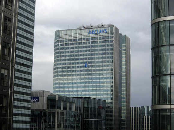 The letter 'B' of the signage on the Barclays headquarters in Canary Wharf is hoisted up the side of the building in London.