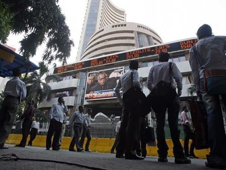 People look at a large screen on the facade of the Bombay Stock Exchange (BSE) building in Mumbai