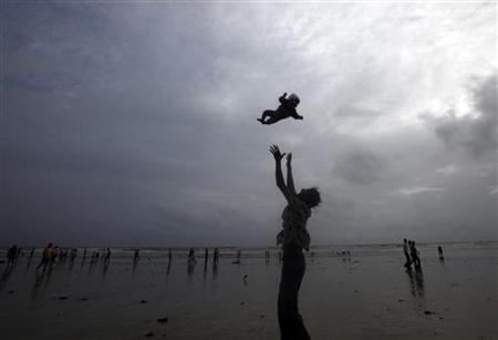 A man plays with his child on a beach in Mumbai.
