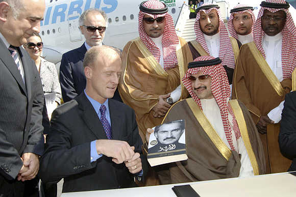Chairman of Kingdom Holding Company Prince Alwaleed bin Talal gives a signed copy of his autobiography to Airbus President and CEO Tom Enders in Dubai.