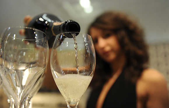 A woman fills glasses with sparkling wine in Verona, Italy.