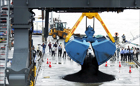 A crane unloads coal from a ship during the inauguration ceremony of Adani Cargo Port at Dahej.