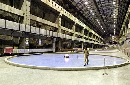 An employee walks inside the power generation unit of the 1450 MW underground riverbed power project at the Sardar Sarovar dam in Kavadia.