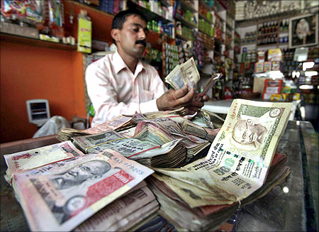 A shopkeeper counts Indian currency notes inside his shop in Jammu.