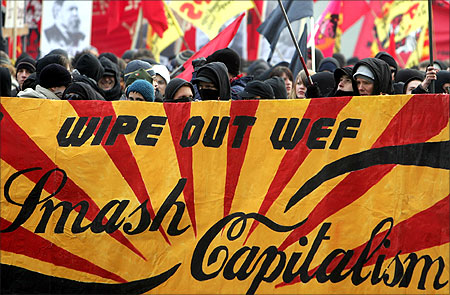 Demonstrators hold banner that reads: 'Wipe out WEF, smash capitalism' during a demonstration.