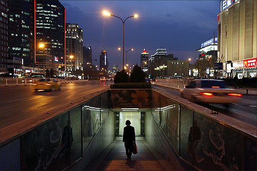 A woman walks into a subway in the central business district of Beijing.