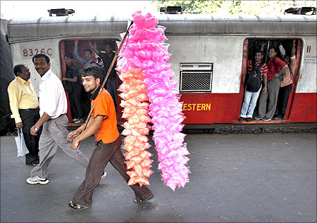 A candy seller walks past a suburban train at a railway station in Mumbai.