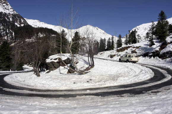 A truck moves on a road after it was cleared of snow near Gulaba village in Himachal Pradesh.