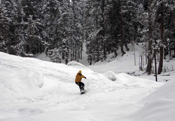 A man snow boards down a slope in Gulmarg, Jammu and Kashmir.