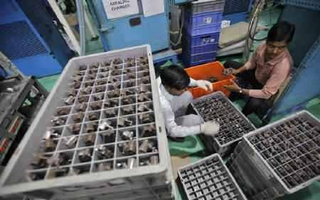 Employees pack auto components at the factory an auto parts making company