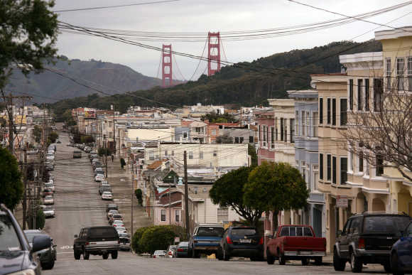 The Golden Gate Bridge rises above tightly packed homes in the Richmond District in San Francisco.