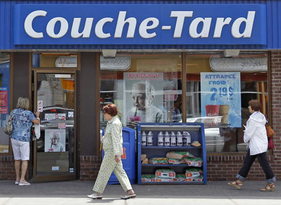 People walk past Couche-Tard store in Quebec City, Canada.