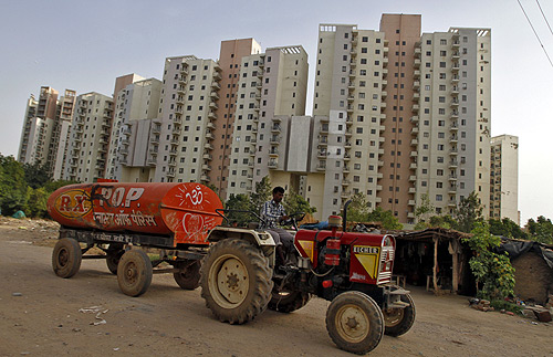 A water tanker moves past Malibu Towne residential apartments at Gurgaon.