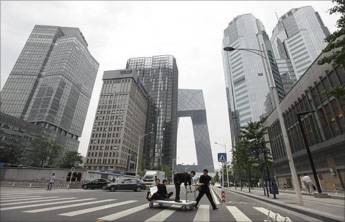 Waiters from a hotel cross a road in Beijing's Central Business District.