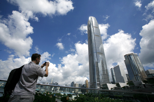 A visitor takes a picture in front of Two IFC, Hong Kong