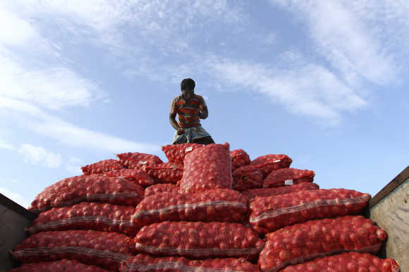 A labourer unloads sacks of onions from a supply truck at a vegetable wholesale market in Chennai.