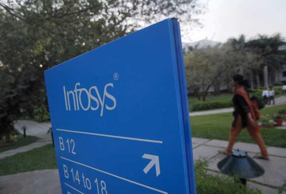 An employee walks past a signage board at the Infosys campus at the Electronics City IT district in Bengaluru.