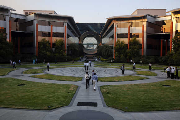Employees walk in front of a building dubbed the 'washing machine', a well-known landmark built by Infosys at the Electronics City IT district in Bangalore.