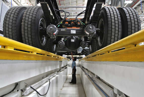 An employee inspects the engine of a BharatBenz truck inside Daimler's factory in Oragadam in Tamil Nadu.