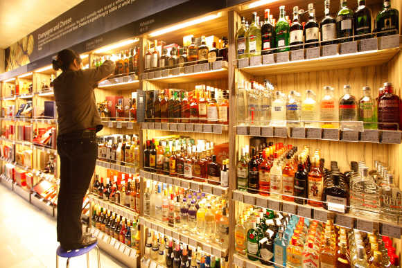 An employee arranges bottles of whisky at a supermarket in Shanghai.
