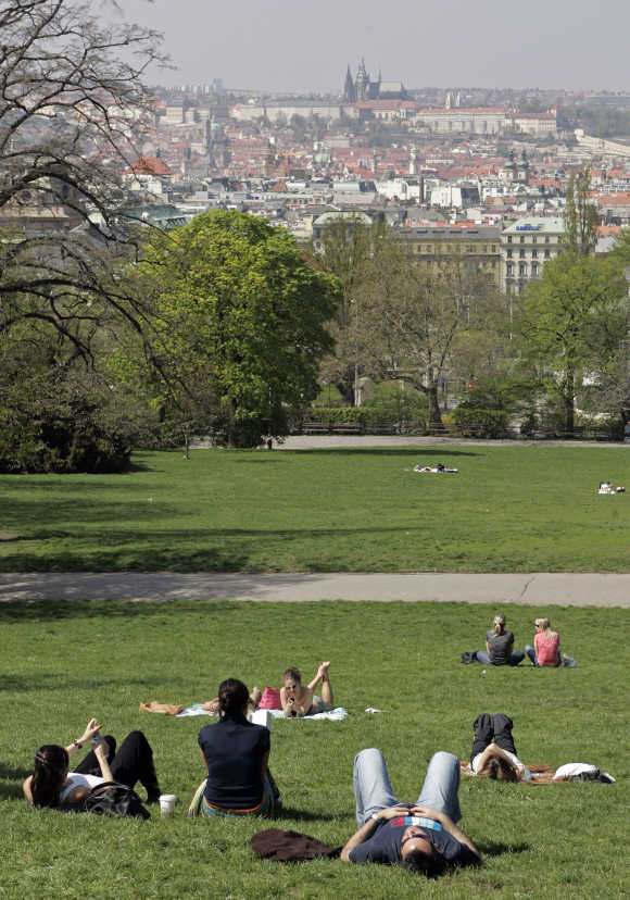 People enjoy a sunny day in a park in Prague.