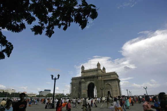 People stroll along the seafront near the Gateway of India in Mumbai.