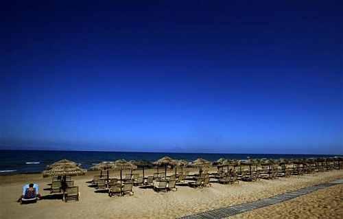 A tourist sits on a sunbed on the beach of the Olympia Riviera resort in the town of Killini, some 285 kms southwest of Athens