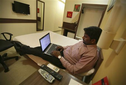 A guest works on a laptop inside his room at the Tata Group's Indian Hotels Co.