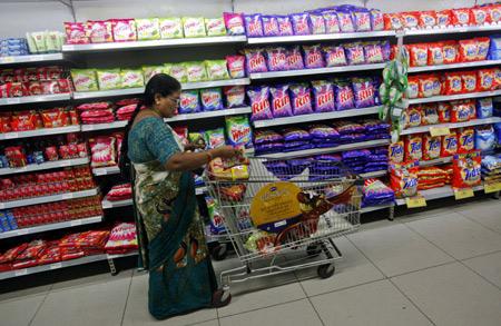 A woman fills her trolley with retail products as she shops at a Hypercity department store, one of Mumbai's largest.