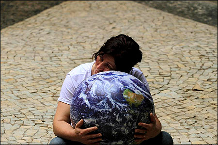 An environmentalist embraces a globe at the entrance of the Brazil Pavilion for the Rio+20 United Nations sustainable development summit in Rio de Janeiro.