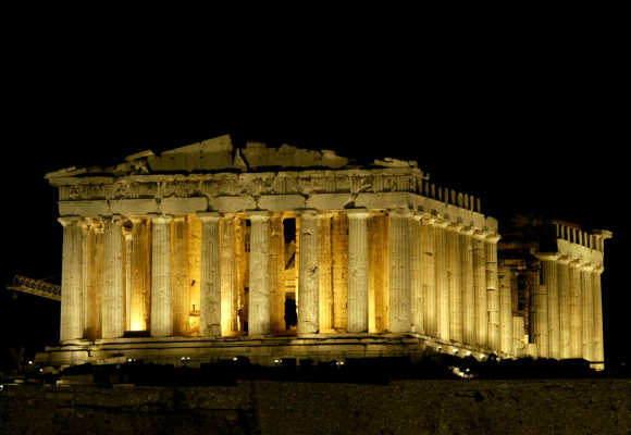 The ancient temple of the Parthenon is illuminated on the Acropolis Hill in Athens.
