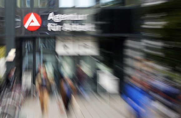 People walk in front of an unemployment office in Berlin.