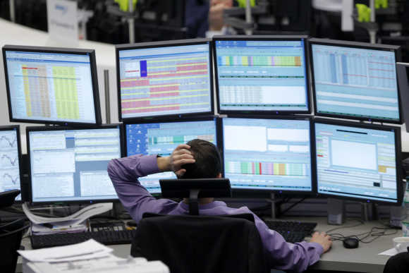 A trader watches screens at his desk at the Frankfurt stock exchange.