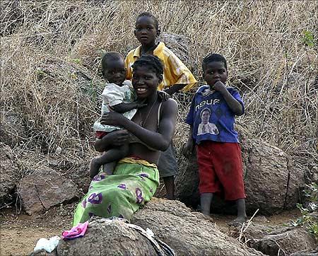 A local woman waits with her children for her husband to return from fishing in the Cahora Bassa dam in Tete province.