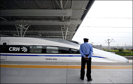 A member of staff stands in front of a CRH high-speed train at Shanghai Hongqiao Railway Station.