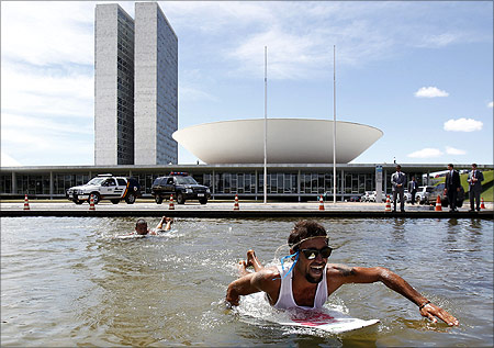 Brazilians use surfboards in the pond next to National Congress during a protest against the new Forestry Law being debated by the legislature in Brasilia.