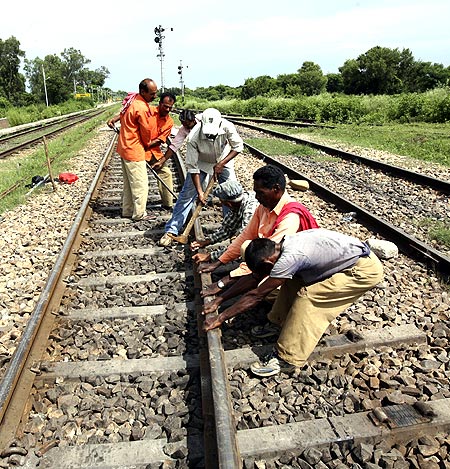 Railway labourers repair a railway track after it was damaged by protesters at Ghagwal.