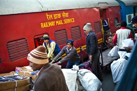 Workers load mail onto a train.