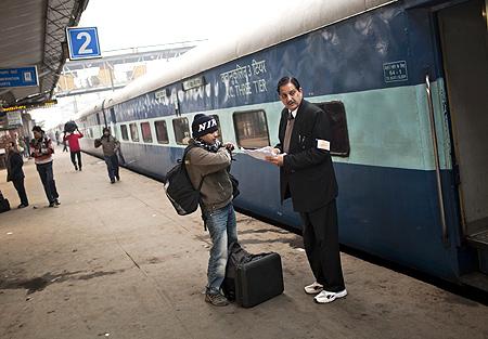 passenger checks his seating on the Amritsar bound train, as he receives help from a conductor at the Nizamuddin Railway Station.