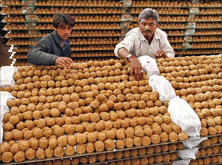 Workers arrange Laddus (sweets) at a temporarily built kitchen in Ahmedabad.
