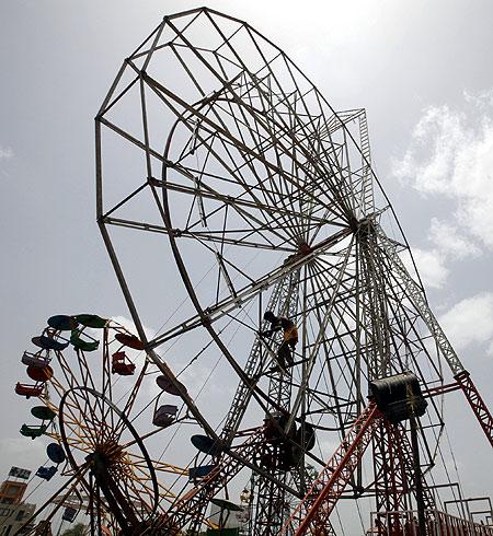 A worker dismantles a ferris wheel after the end of a fair in the western Indian city of Ahmedabad.