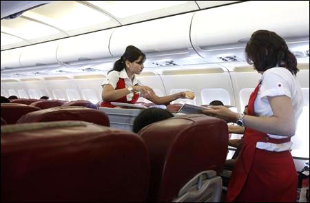 Kingfisher Airlines cabin attendants serve snacks on a flight after takeoff from Mumbai's domestic airport.