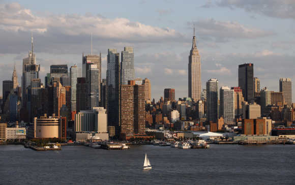 A boat sails in the Hudson River in front of the Empire State Building and the skyline of midtown Manhattan in New York.
